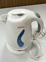Full view Sunbeam white electric kettle front, base, cord visible