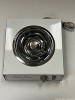 Top view showing single coiled burner and white metal body
