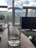 Full view of clear cylindrical glass vase standing on table