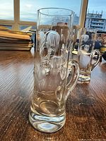 Tall clear crystal shot glass with etched floral design and handle