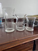 Three cups of different sizes showing shape, handle, and etched star pattern