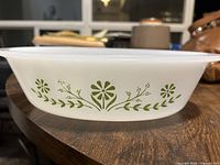 Side view showing green floral motif on white milk glass dish