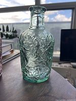 front view green bottle showing embossing detail