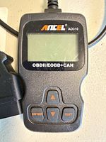 Front view of ANCEL AD310 code reader showing screen, keypad and connector