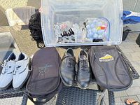 Overall lot showing both shoe pairs, two gear bags, gloves and balls in bin