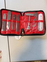 open case displaying red interior and interchangeable tools