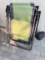 Two chairs folded showing fabric colour and frame