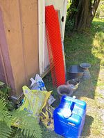 Group view of water container, salt bags, fencing roll, metal planters
