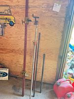 Overall view of four adjustable clamps/props leaning against wall