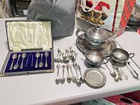 group shot of boxed teaspoon set, tea service pieces, decorative spoons and coaster