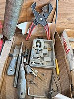 Box contents showing pliers, flaring kit, file, screwdriver, socket, hex key and small parts