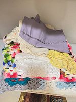 Stack of linens showing afghan, pillowcases, crochet doilies
