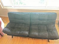 Front view of futon in sofa position showing microfiber upholstery and divided back