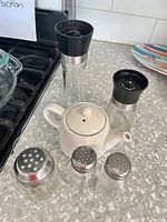 Full set showing teapot, two grinders, three shakers