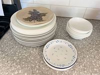 Stacked plates and bowls showing decorative grape plate, bowls, dessert plates
