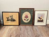 Group shot of three framed artworks standing side by side