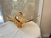 Three-arm amber freeform glass bowl on display stand