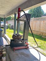 Full view of shop press on bench showing frame, cylinder, pump, press plates