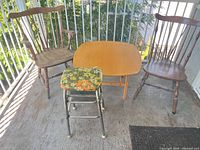 Overall view of table, two Windsor chairs, floral step stool