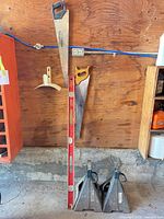 Overall lot view showing jack stands, two handsaws, red level