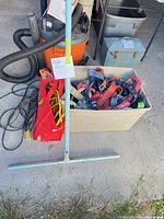 Overall lot view showing squeegee, extension cord in red bag and tote with harnesses and straps
