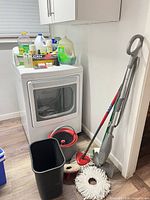 Group shot showing steam mop, spin mop bucket, mop heads, trash bin and assorted cleaning products