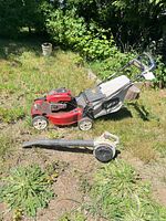 Side view of Toro mower with grass bag and Echo leaf blower on ground