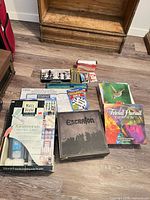 Group shot of all boxed games, craft kits, chess set, cribbage set, crossword book and envelopes