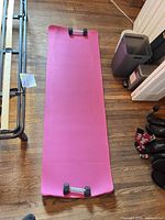 pink yoga mat with dumbbells placed at ends