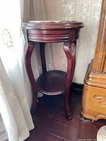 Full view of mahogany round side table beside window