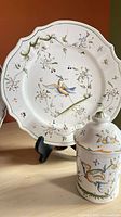 Plate with bird flying among flowers on stand