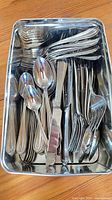 All flatware pieces in metal tray