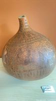 Full view of large carved gourd vessel on table