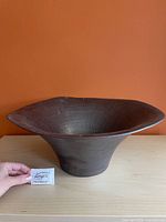 Side view of flared terracotta bowl on table