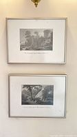 Two framed engravings hung on wall showing silver metal frames and white mats