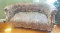 Full view of paisley upholstered loveseat