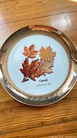 Front of porcelain plate showing maple leaves and gold rim
