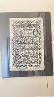Front view of framed black and white linocut print