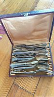 Open case displaying stacked forks and spoons