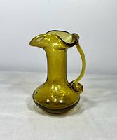 front angled view showing amber glass cruet jug, applied handle, spout