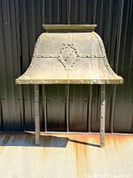 Full frontal view of brass fireplace hood with iron legs