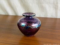 Full view of vase front showing iridescent purple colour and blue-green trailing