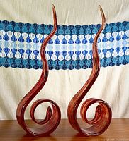 Pair of matching red spiral ribbon glass sculptures standing side by side