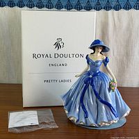 Figurine displayed in front of branded Royal Doulton box with certificate packet