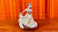 Full view of figurine front, shows pose and gown