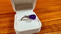 Ring in box showing amethyst stone and band