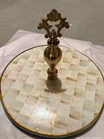 Top view of ceramic cake stand showing checkerboard pattern and brass finial