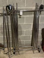 bundle of chrome shelving poles and frame pieces leaning against wall