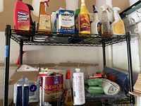 Overall view of shelving with spray cleaners, teak oil jug, deck stain can and accessories