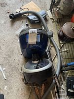 Top view of blue Miele Plus canister with hose and floor head visible